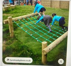 three people in blue shirts are climbing on a wooden structure with green ropes and poles