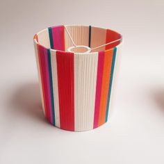 a multicolored striped basket sitting on top of a white table