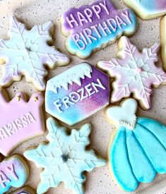 decorated cookies on a plate with happy birthday written on them and frosted snowflakes