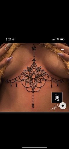 a woman's chest with an intricate tattoo design on her stomach and the words ug above it