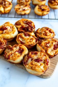 several mini pizzas on a wooden tray