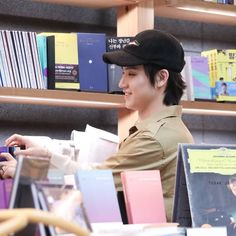 a man in a hat is looking at books