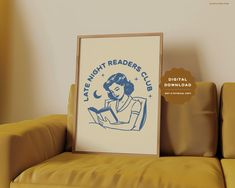 a framed poster sitting on top of a couch next to a yellow chair with the words late night readers club