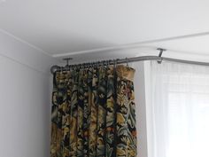 the curtain is hanging on the rod in the room with the curtains pulled back from the ceiling