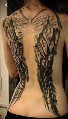 a woman's back with an angel wing tattoo on her upper and lower back