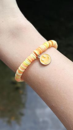 This super cute clay bead bracelet is made with high quality beads. It has a randomized pattern with different shades of the colors: -orange  -yellow There is a dark yellow dangling smiley face charm in the center of the bracelet. Please note that colors and pattern may vary from each bracelet. All bracelets vary from 6.5 inches to 6.75 inches.  While the string I use is high quality, be careful not to overstretch the bracelet as it will shorten its lifespan. In addition, keep out of water as it will shorten the lifespan of the bracelet. Excessive sweating and water exposure may also rust any gold beads if there are any gold beads on the bracelet.  WARNING: keep out of reach of children as this product is a choking hazard. 🚨HOW TO GET BUY 4 GET ONE FREE: 🚨 -add 4 items to your cart -when Yellow Beaded Bracelets With Smiley Face, Yellow Clay Bead Bracelet, Clay Bead Bracelet, Excessive Sweating, Colors Orange, Clay Bead, Cute Clay, Free Bracelet, Dark Yellow