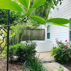 an outdoor hot tub surrounded by plants and flowers