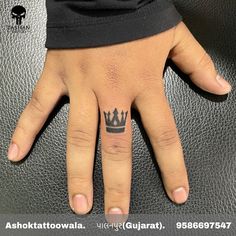 a hand with a crown tattoo on it