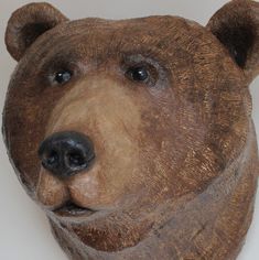 a brown bear's head is shown on a white wall