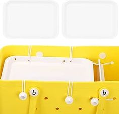 a yellow plastic storage container with two compartments and three dividers on each side, holding various items