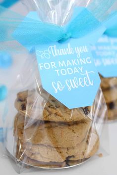 a bag filled with cookies sitting on top of a white table next to a blue ribbon