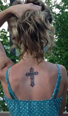 a woman with a cross tattoo on her back