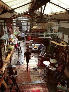 a man walking through a room filled with lots of furniture and other items on top of a rug