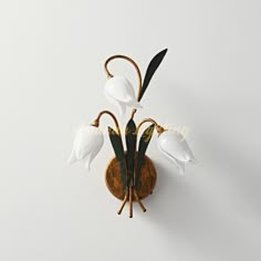 a wall mounted clock with white flowers on it's face and two black hands