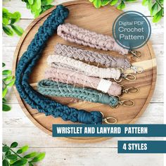 four braided and layered lanyard patterns on a wooden platter with green leaves