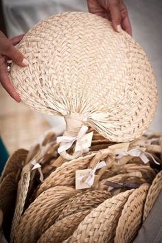 a person is holding a large hat in their hand and it's made out of straw