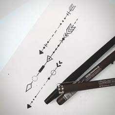 two pens sitting next to each other on top of a piece of paper with arrows drawn on it