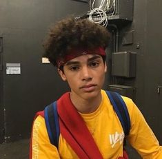 a young man wearing a yellow shirt and red headband