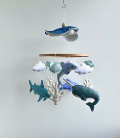 a mobile with sea animals hanging from it's sides and two dolphins on the other side