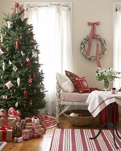 a living room with a christmas tree and presents on the floor in front of it