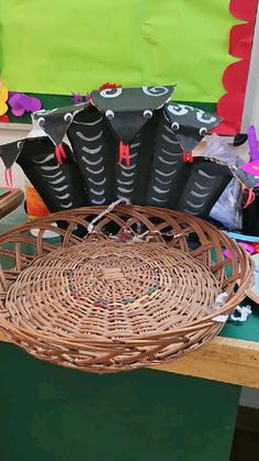 a wicker basket sitting on top of a wooden table filled with black paper bags