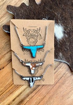 Western Longhorn Shaped Charm Necklace featuring Faux Cowhide Fabric or Faux Turquoise Stone Necklace chain measures 17.7-19.7 inches in adjustable length Longhorn charm measures 1.3 inches in width, 0.75 inches in height. ** Made with alloy metals Southwestern Style Necklace With Adjustable Length As Gift, Western Style Blue Necklace For Gift, Cowhide Fabric, Long Horn, Faux Cowhide, Cow Head, Horn Necklace, Head Jewelry, Gift Wrapping Services