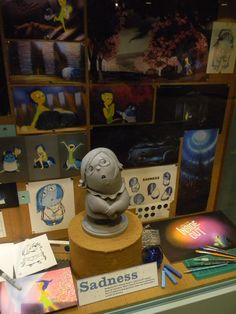 there is a display case with various items on it, including an elephant statue and other artwork