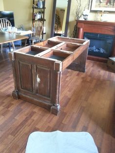 a wooden bed frame sitting on top of a hard wood floor next to a fireplace