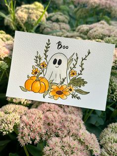 a card with a ghost surrounded by flowers