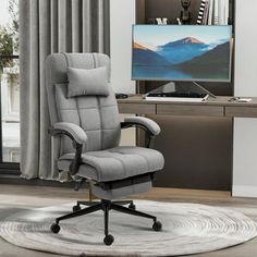 a grey office chair sitting in front of a computer desk with a monitor on it