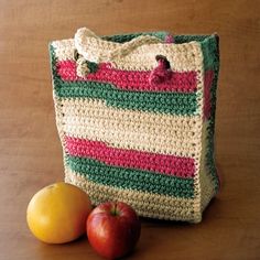 a crocheted bag sitting next to an apple on a table