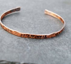 Our delicate copper bracelet is hand forged from rich jewelers copper. The bangle style cuff has been hammered, polished and oxidized giving it a warm, rich patina.A perfect gift with your special date stamped in Roman Numerals.The cuff is beautiful worn alone or stacked with others. I wear one with the coordinates of my daughter's birthplace and another with her birthdate.Copper is the traditional 7th or 22nd wedding anniversary gift, but this is lovely for any occasion.To maintain  the patina 22nd Wedding Anniversary, Date Bracelet, Roman Numeral Bracelet, 22nd Anniversary, Copper Anniversary, Copper Gifts, 7th Anniversary Gifts, 7th Anniversary, Oxidized Copper