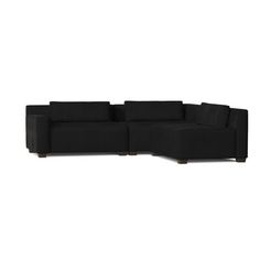 a black sectional couch sitting on top of a white floor