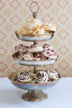 three tiered trays filled with different types of pastries on top of each other