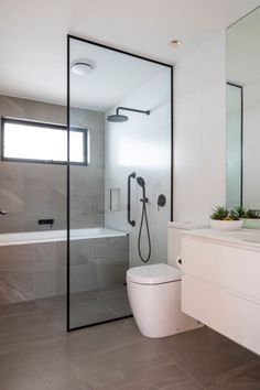 a white toilet sitting next to a walk in shower