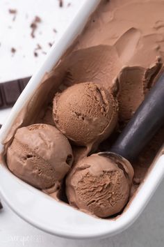 three scoops of chocolate ice cream in a white dish