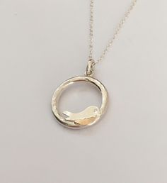 Silver and 9ct Gold Shell Robin Necklace. A solid silver and 9ct gold robin on a circle pendant with a silver chain. Completey handmade in our workshop. The pendant is approximately 20mm diameter. Various chain lengths available.  Comes in a little gift bag, gift boxes available by request. Robin Necklace, Silver Bird Necklace, Earrings Bird, Silver Bird, Nature Necklace, Bird Necklace, Bird Earrings, Circle Pendant, Necklace Silver