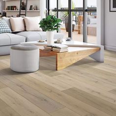 a living room with white furniture and wood flooring in front of a large window