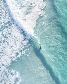 a person riding a surfboard on top of a wave in the ocean next to shore