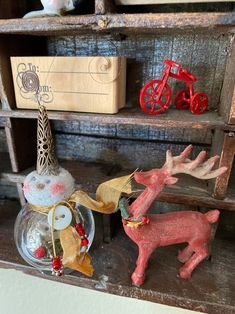 an old wooden shelf with christmas decorations and deer figurines