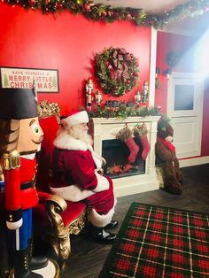 a man dressed as santa claus sitting in front of a fire place