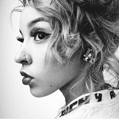 a black and white photo of a woman's face with her hair pulled back