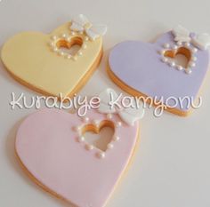 three decorated cookies in the shape of hearts