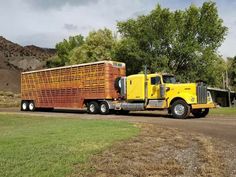 a large yellow truck driving down a rural road