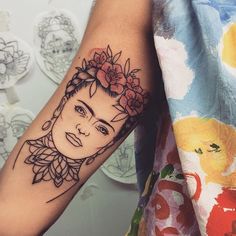 a woman's face with flowers in her hair on the left forearm and right arm