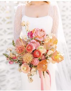 a bride holding a bouquet of flowers on her wedding day