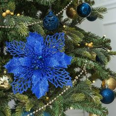 a blue christmas ornament hanging from the top of a tree