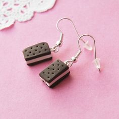 black and white ice cream sandwich earrings on pink background