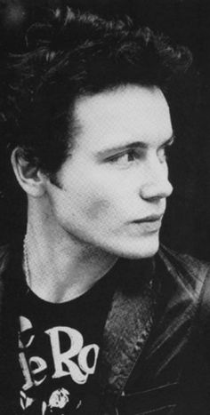 a black and white photo of a man in a leather jacket looking off to the side