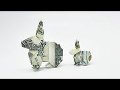 two origami dogs made out of money sitting side by side on a white surface